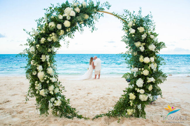 flower arch with wedding couple