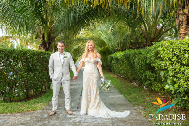 bridal couple in resort garden holding hands