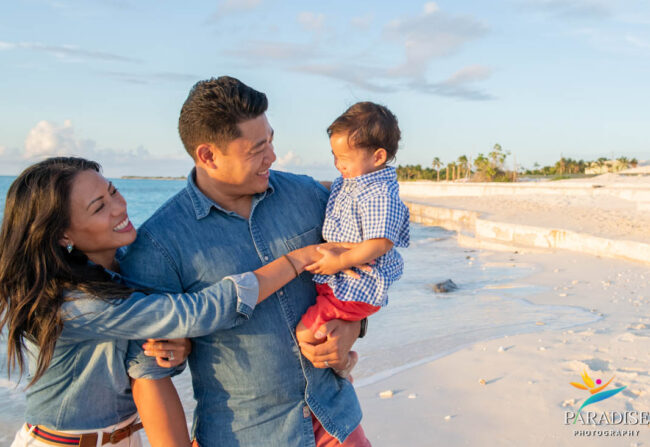 mom and dad with son on the beach