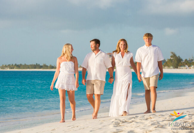 family walking along grace bay beach