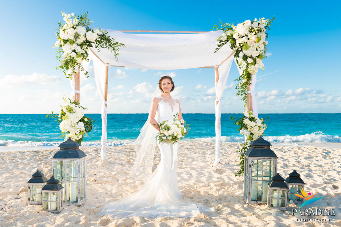 bride under arch on the beach