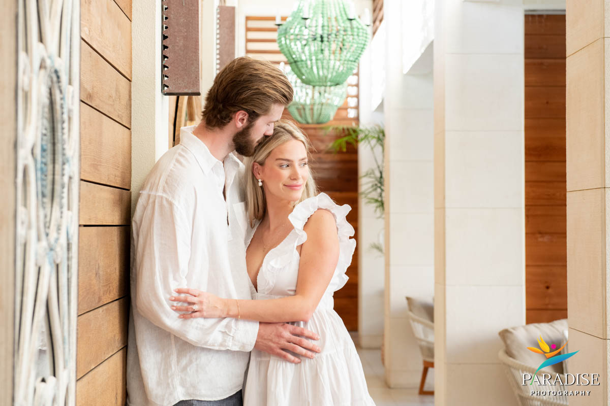 Couple in coordinated white outfits sharing a quiet moment indoors