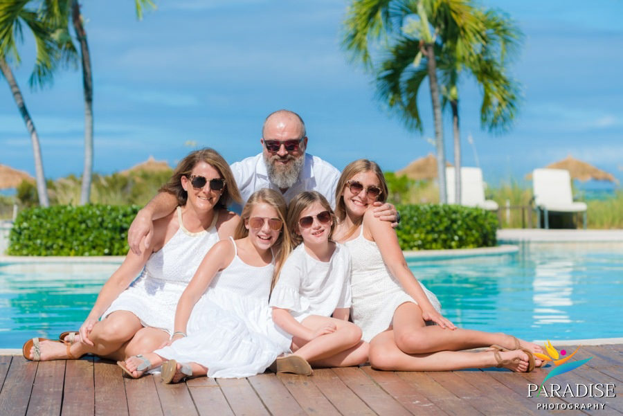 family with sunglasses on bye the pool at the resort