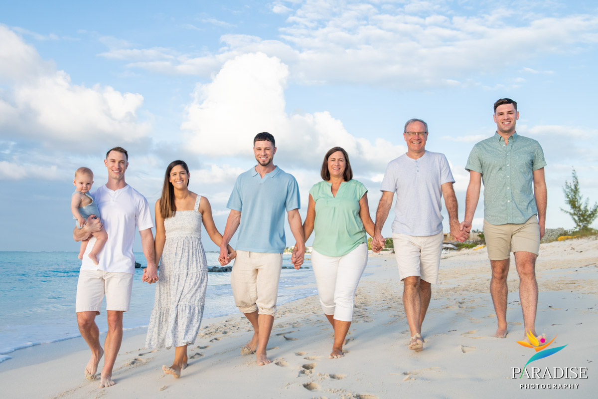 large family holding hands on beach