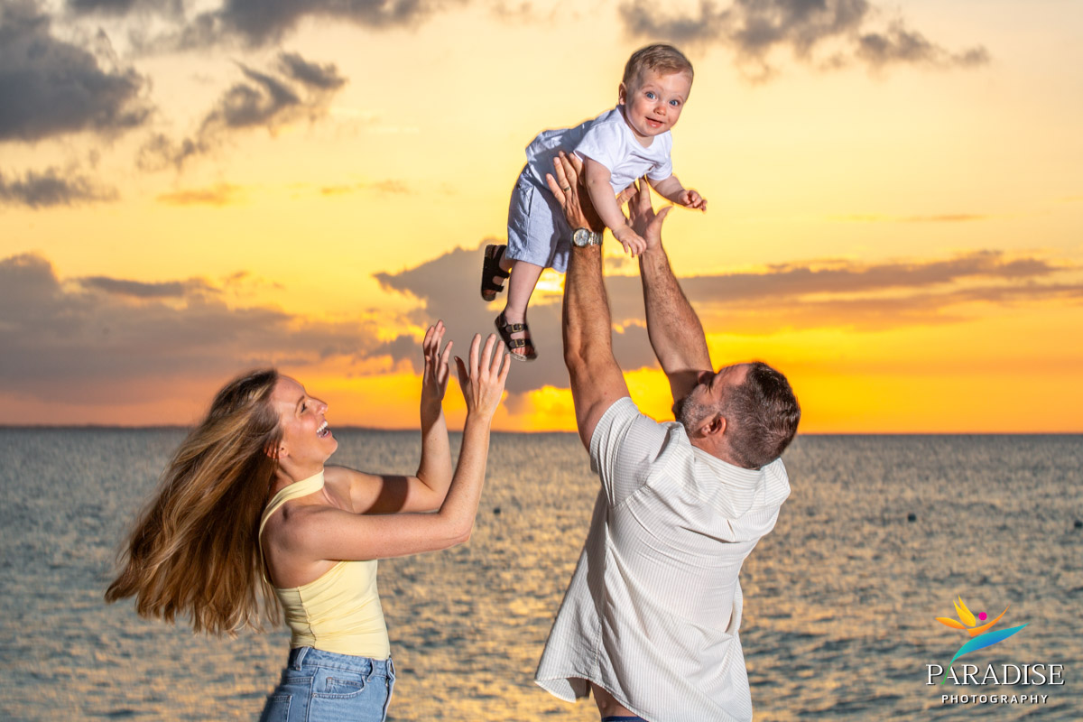 family of three on beach in turks and caicos setting on beach