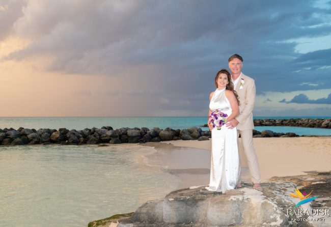 A romantic sunset silhouette of a couple kissing on the beach, with the sun dipping below the horizon and casting a golden glow on the water.