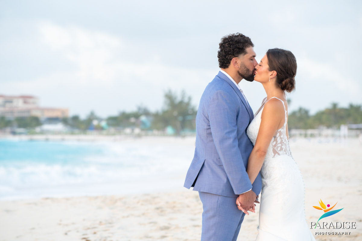 bride and groom kissing on the beach
