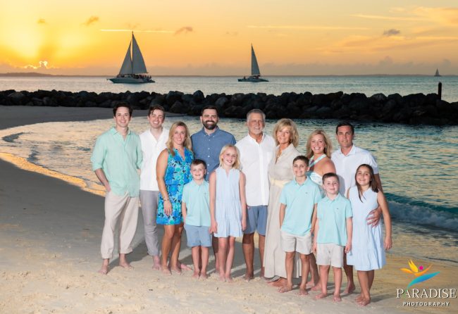 the whole family on the beach as the sun deeps down over the sea