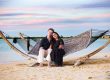A beautiful family couple relaxing in a hammock on a serene beach