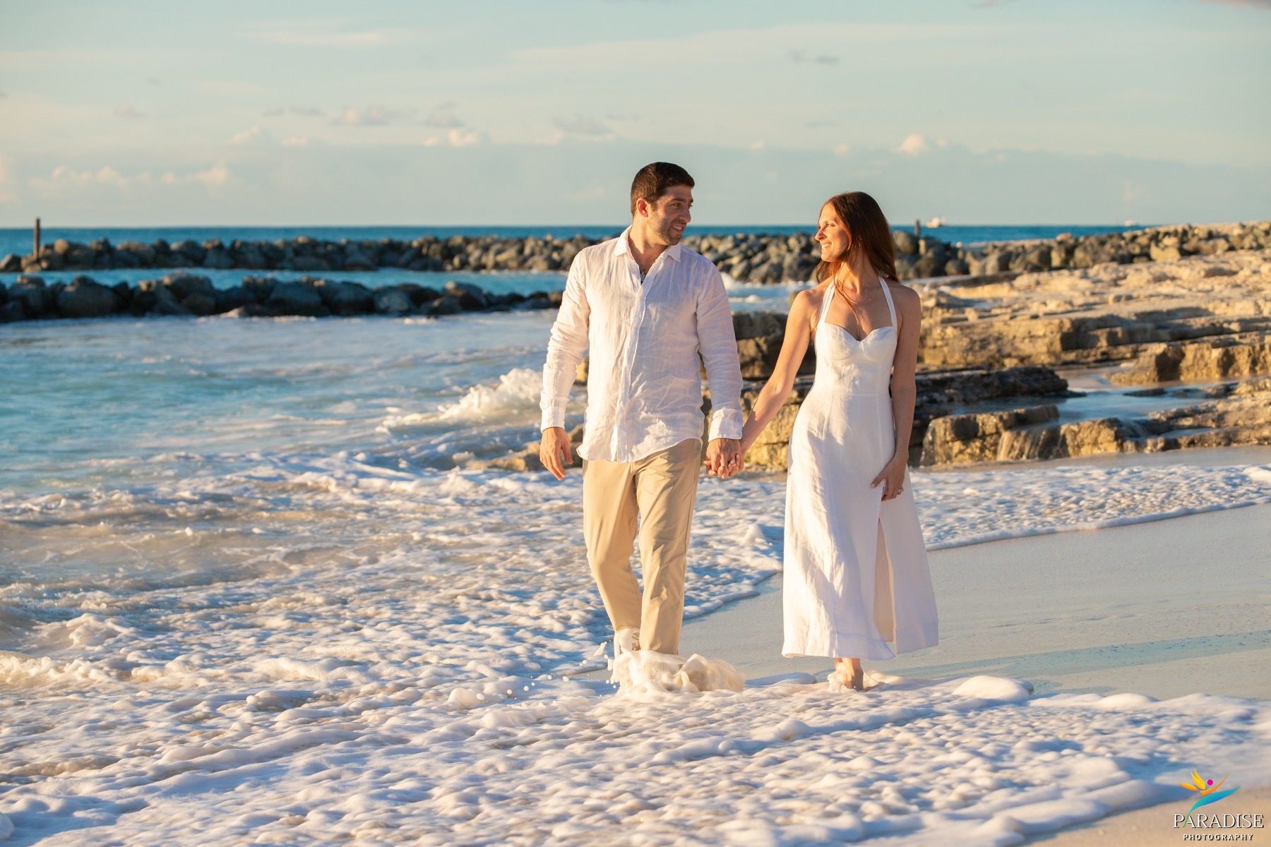 A beautiful family posing for a portrait among white sand dunes by the ocean