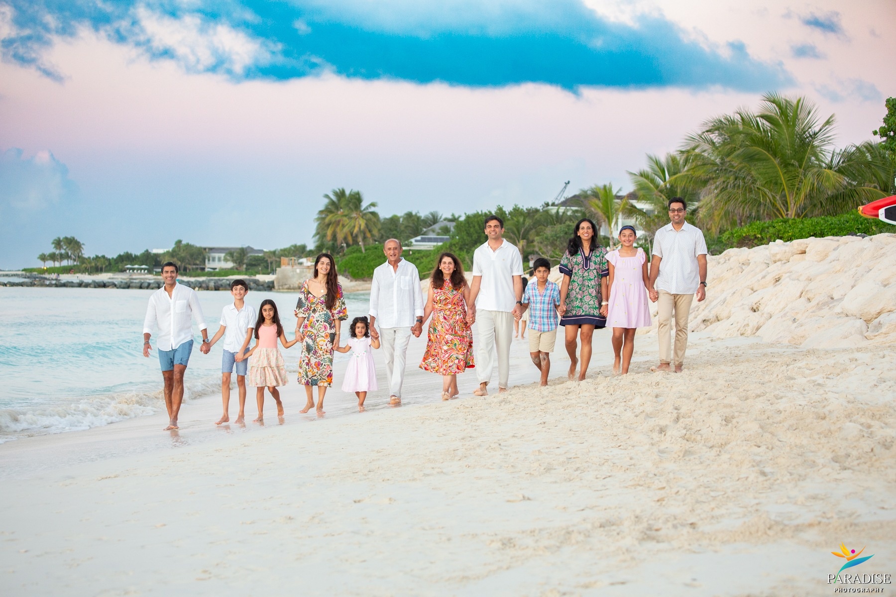 A beautiful family walking the beach together during a breathtaking sunset