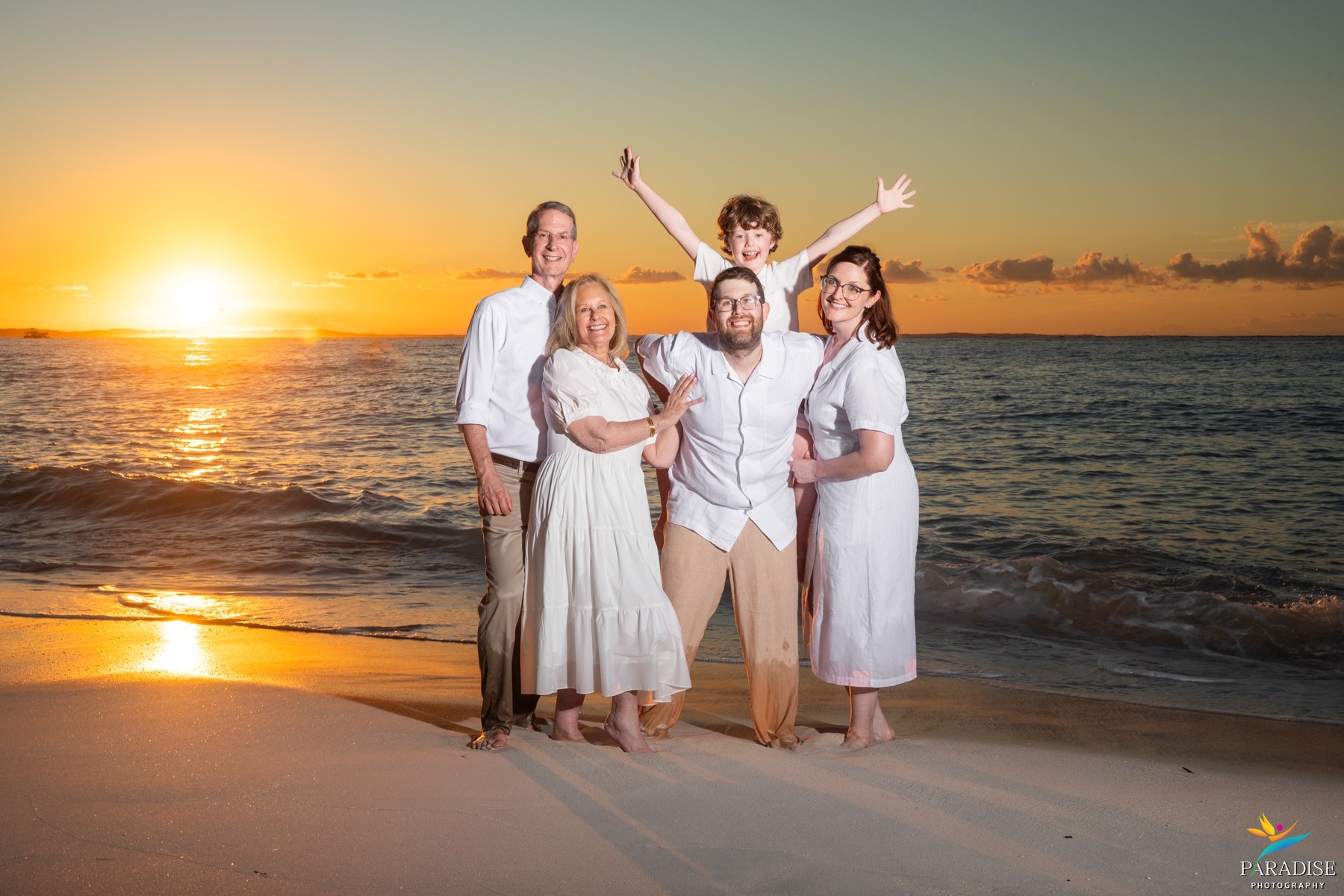 A beautiful family gathered together for a group portrait on a tropical beach