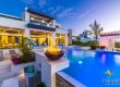 Providenciales luxury villa illuminated pool with fire bowl feature at evening dusk