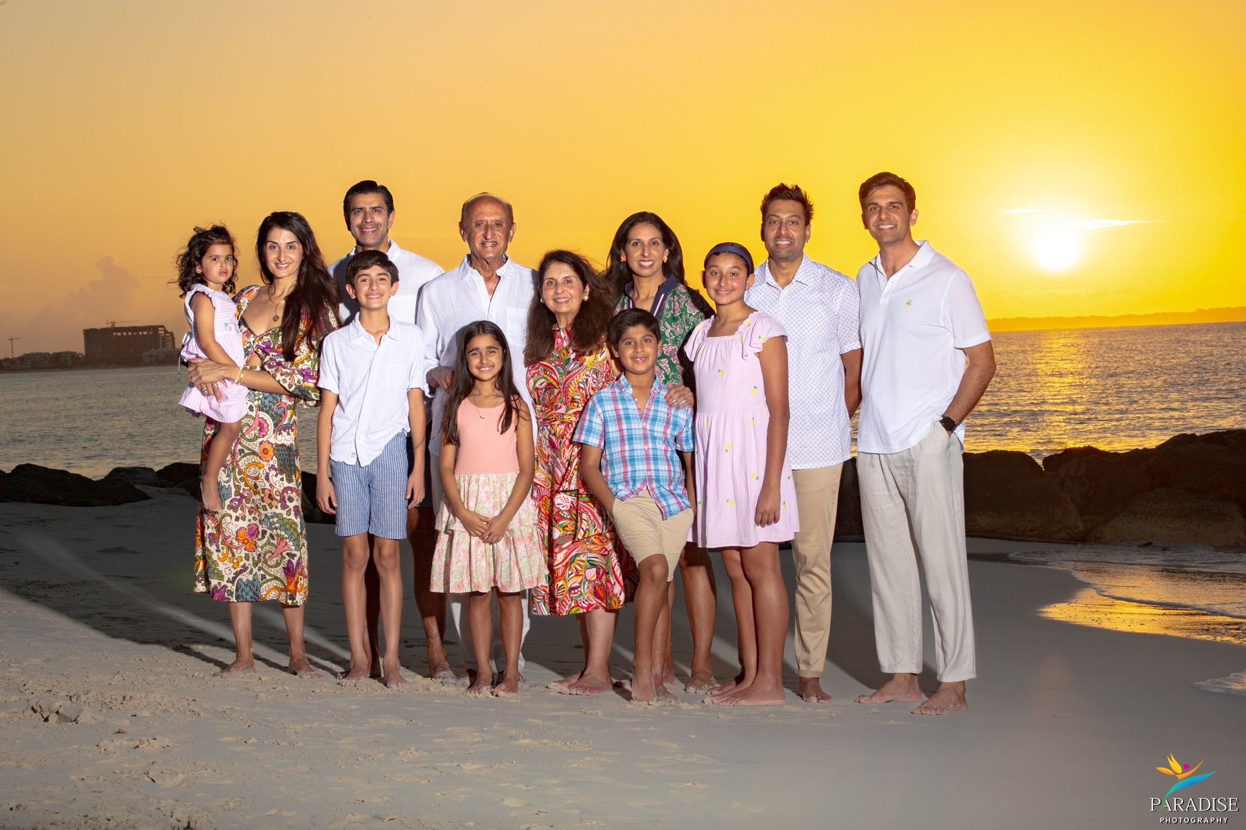 A beautiful family posing together on the beach at golden sunset