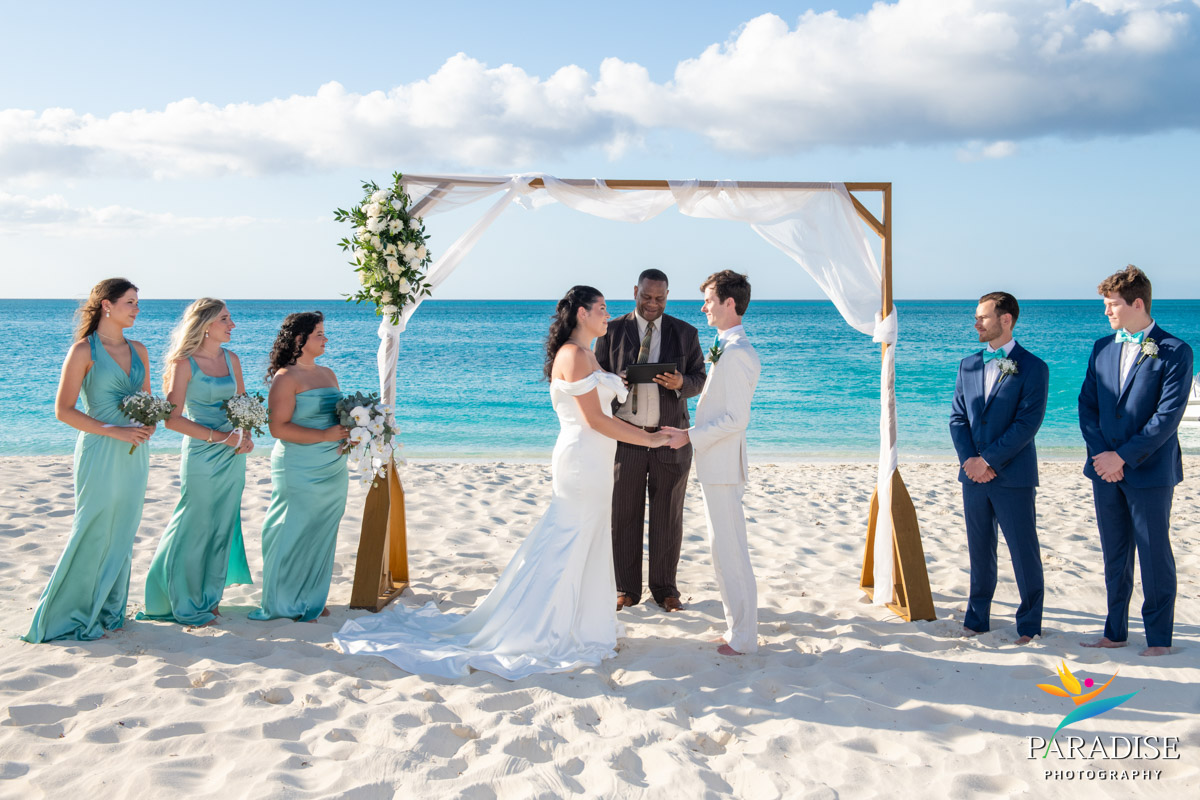 Bride and groom exchange vows under a beach arch at their Ritz-Carlton Turks and Caicos wedding ceremony