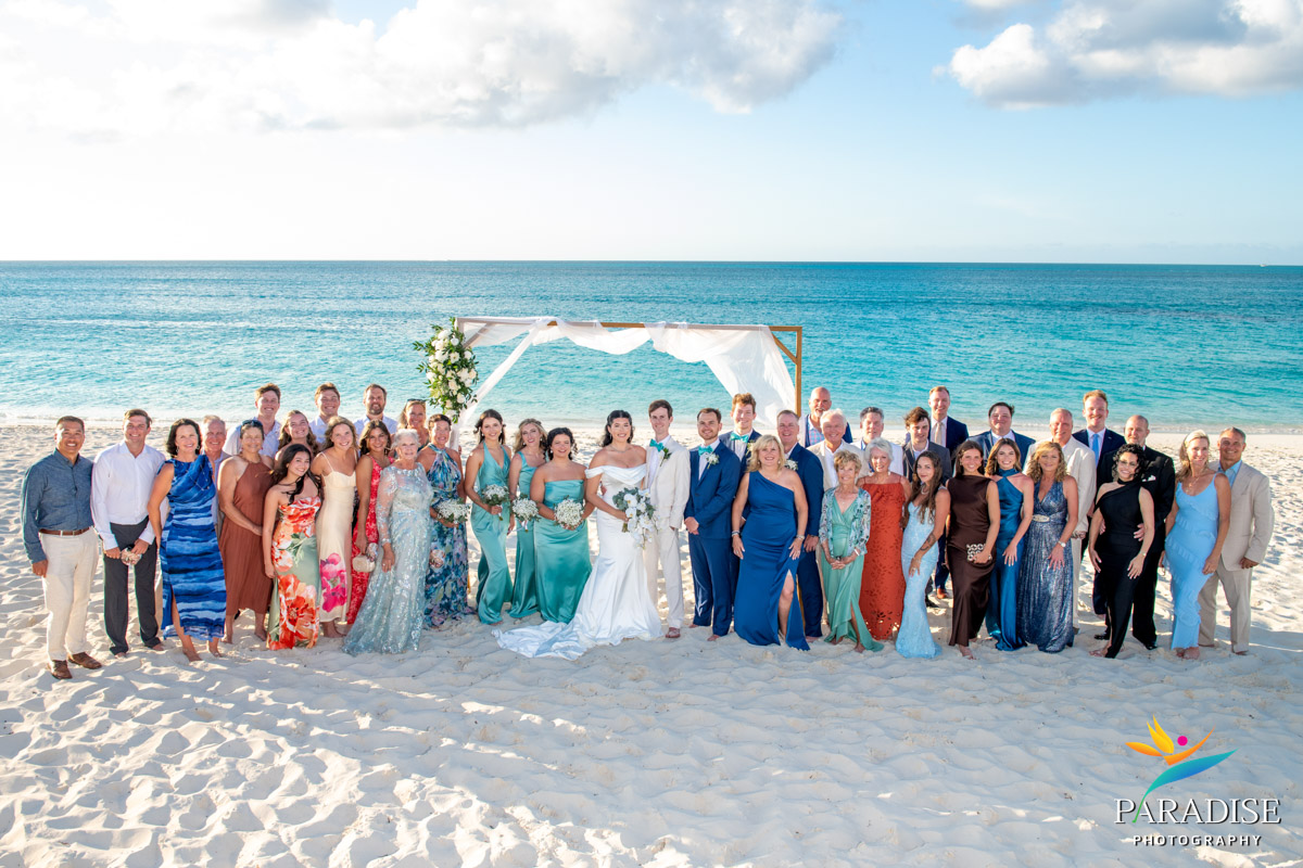 Full wedding group photo on the beach with ceremony arch at Ritz-Carlton Turks and Caicos