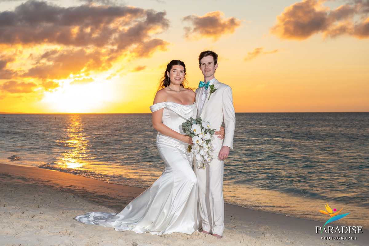 Bride and groom pose together on the beach at sunset during their Ritz-Carlton Turks and Caicos wedding