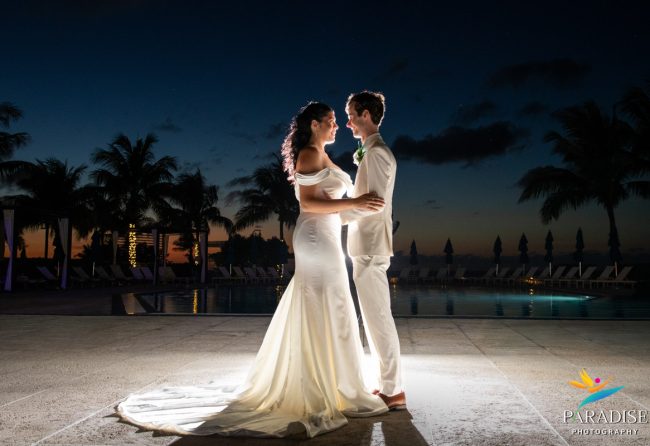 Bride and groom embrace at night by the pool during their Ritz-Carlton Turks and Caicos wedding