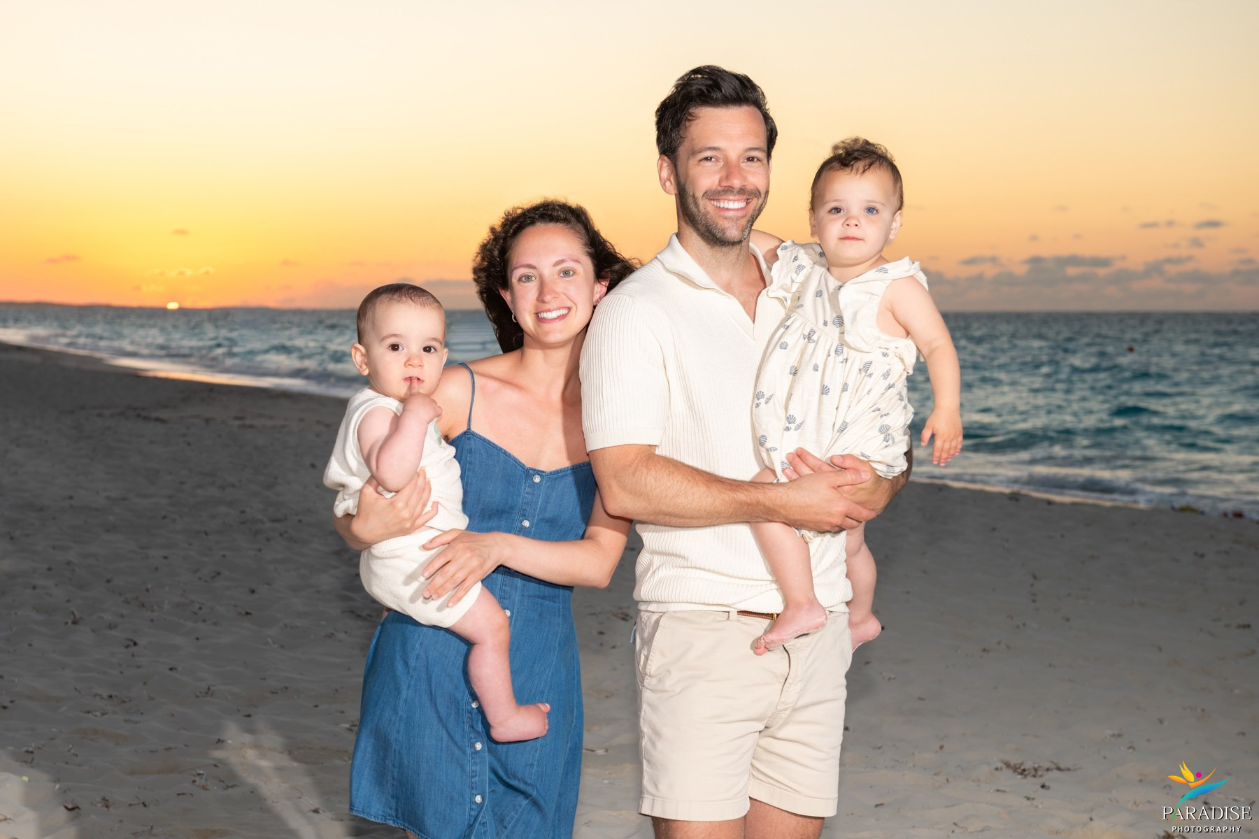 family of four on the beach happy and smiling