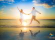 Couple jumping on the beach at sunset with reflection, captured by a Turks and Caicos couples photographer